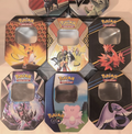 Assortment of official large Pokémon tins featuring Pikachu, Zapdos, Moltres, Mewtwo, Clefairy and more